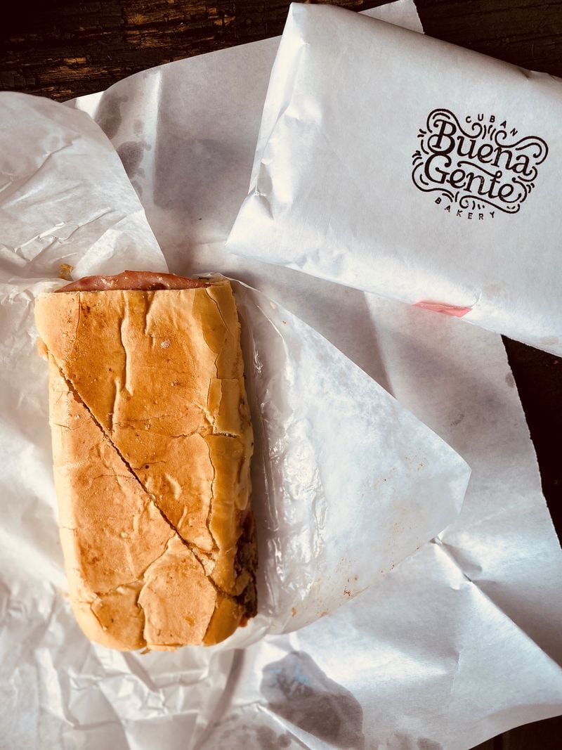 This takeout order from Buena Gente Cuban Bakery includes an unwrapped Cuban and a croqueta preparada. Wendell Brock for The Atlanta Journal-Constitution