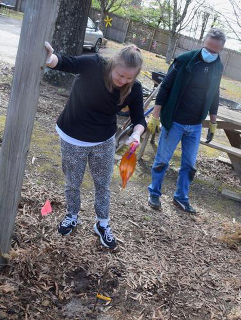 Auburn resident Nicole Recknor, who is one of Creative Enterprises' special needs clients, waters a newly planted grapevine that is part of an orchard at Creative Enterprises on March 24. (Courtesy of Curt Yeomans)
