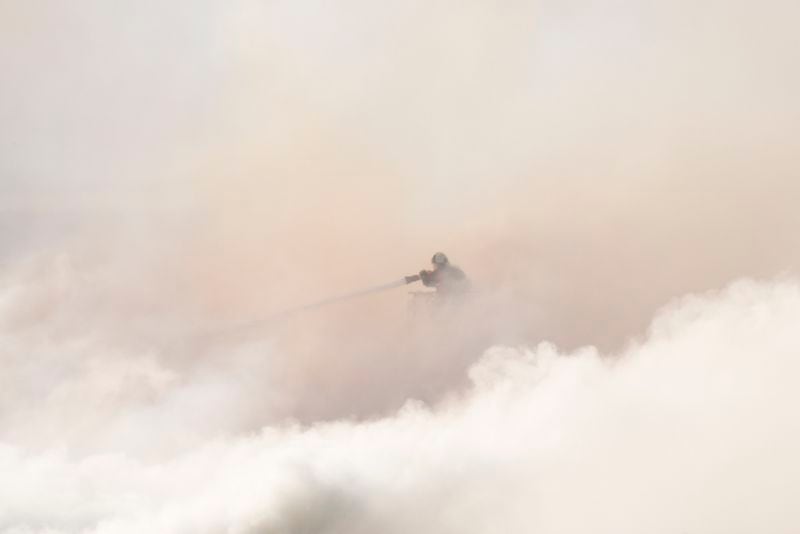 A firefighter works as smoke rise out of the Old Stock Exchange, Boersen, in Copenhagen, Denmark, Tuesday, April 16, 2024. One of Copenhagen’s oldest buildings is on fire and its iconic spire has collapsed. The roof of the 17th-century old Stock Exchange, or Boersen, that was once Denmark’s financial center, was engulfed in flames Tuesday. (Emil Helms/Ritzau Scanpix via AP)