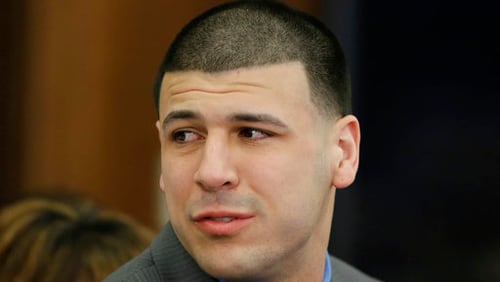 Former New England Patriots tight end Aaron Hernandez turns to look toward his fiancee Shayanna Jenkins Hernandez as he reacts to his double murder acquittal at Suffolk Superior Court Friday, April 14, 2017, in Boston. Hernandez stood trial for the July 2012 killings of Daniel de Abreu and Safiro Furtado who he encountered in a Boston nightclub. The former NFL player is already serving a life sentence in the 2013 killing of semi-professional football player Odin Lloyd. (AP Photo/Stephan Savoia, Pool)