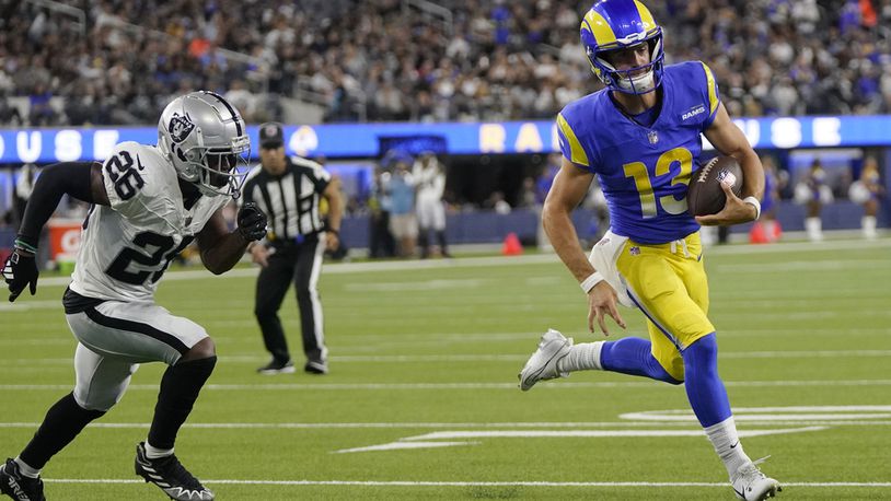 Los Angeles Rams quarterback Stetson Bennett, right, runs for a touchdown past Las Vegas Raiders safety Jaquan Johnson during the second half of a preseason NFL football game Saturday, Aug. 19, 2023, in Inglewood, Calif. (AP Photo/Mark J. Terrill)