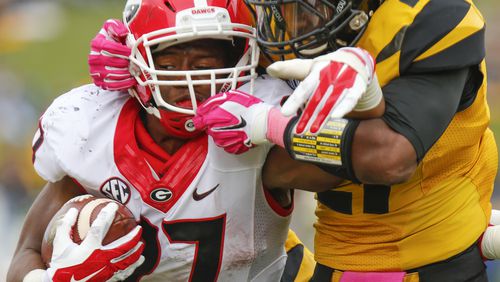 Nick Chubb #27 of the Georgia Bulldogs is wrapped up by Ian Simon #21 of the Missouri Tigers midway in the fourth quarter on October 11, 2014 at Faurot Field/Memorial Stadium in Columbia, Missouri. (Photo by Kyle Rivas/Getty Images)