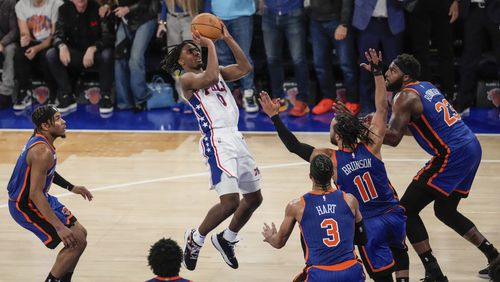 Philadelphia 76ers' Tyrese Maxey (0) shoots over New York Knicks' Jalen Brunson (11), Mitchell Robinson (23) and Josh Hart (3) during the second half of Game 5 in an NBA basketball first-round playoff series, Tuesday, April 30, 2024, in New York. The 76ers won 112-106 in overtime. (AP Photo/Frank Franklin II)