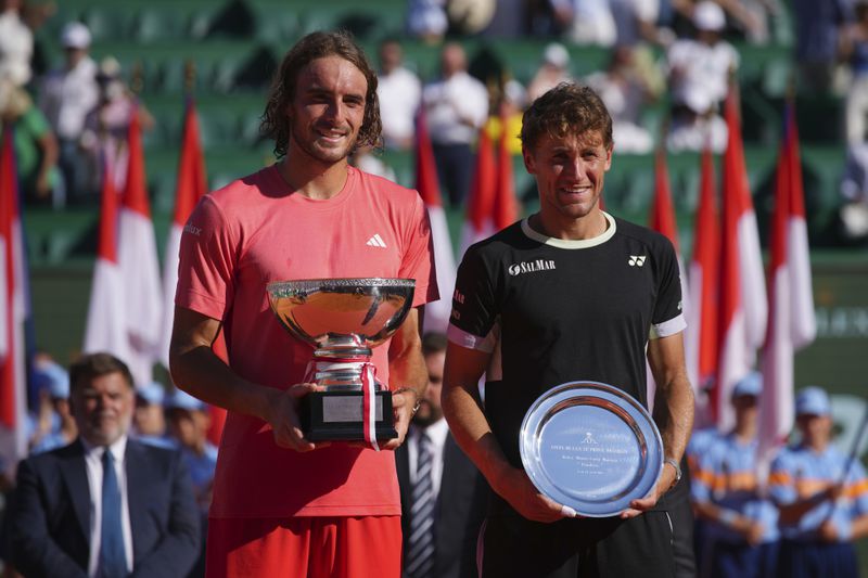 Stefanos Tsitsipas of Greece, left, poses with the trophy alongside runner up Casper Ruud of Norway after the Monte Carlo Tennis Masters final match in Monaco, Sunday, April 14, 2024. Tsitsipas won the match 6-1, 6-4. (AP Photo/Daniel Cole)