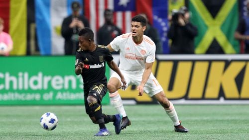April 7, 2018.  Atlanta United defender Miles Robison battles a ball in the mid field against Los Angeles FC #7 Latif Blessing during the first half.