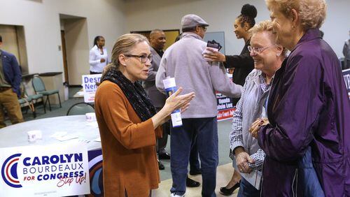 Carolyn Bourdeaux, left, a 7th Congressional District Democratic candidate, greets voters Deborah Teitsman and Carolyn Sudberry at a United Peachtree Corners Civic Association event on Monday in Peachtree Corners. Curtis Compton/ccompton@ajc.com