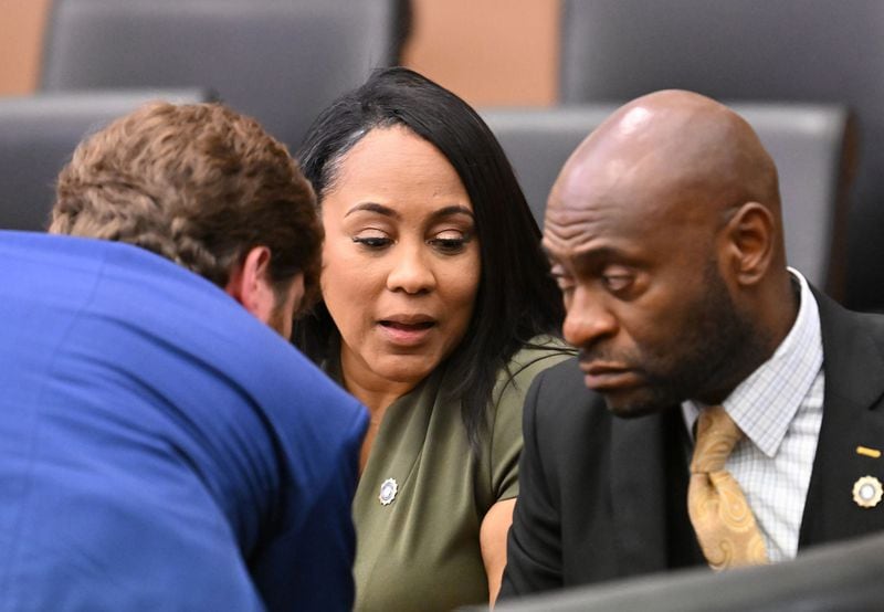 District Attorney Fani Willis, center, confers with lead prosecutors Donald Wakeford, left, and Nathan Wade during a motion hearing at Fulton County Courthouse in Atlanta on July 1, 2022. (Hyosub Shin/The Atlanta Journal-Constitution/TNS)