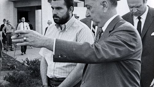 Gary Krist, left, is shown the way back to his jail cell after a hearing in DeKalb County Superior Court in 1969. Krist was later convicted of abducting Barbara Jane Mackie, a 20-year-old Emory student from Miami, and burying her alive in a box with air tubes, food and water.