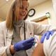 Kelly Moran, a nurse practitioner from south Philadelphia, gives a flu shot to a patient at a CVS Minute Clinic in January 2020. (Tyger Williams/The Philadelphia Inquirer/TNS)