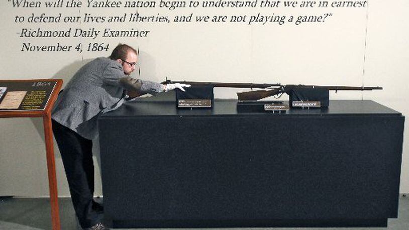 Southern Museum curator Jonathan Scott with rifles on display in the exhibit "1864." BOB ANDRES/ BANDRES@AJC.COM
