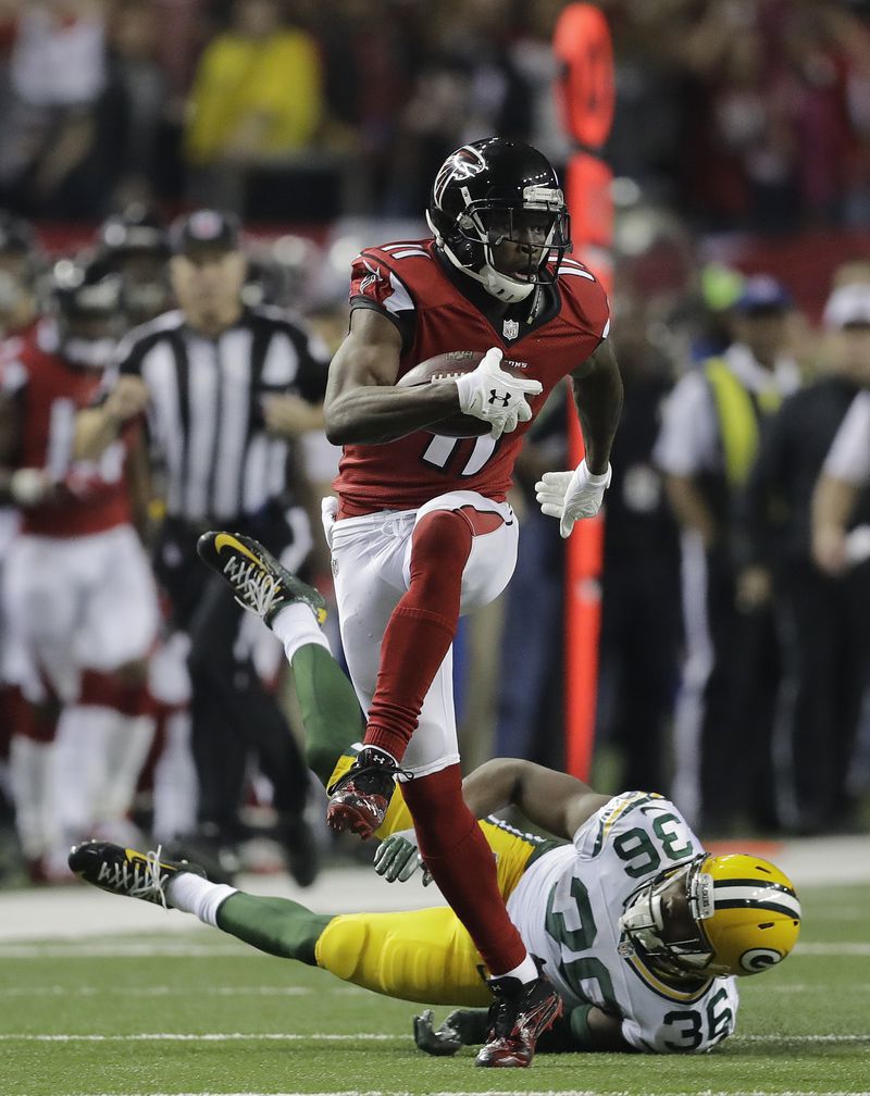 FILE - In this Jan. 22, 2017, file photo, Atlanta Falcons' Julio Jones catches a touchdown pass in front of Green Bay Packers' LaDarius Gunter during the second half of the NFL football NFC championship game, in Atlanta. Atlanta led the NFL in points (540) by a wide margin, thanks to a career year from QB Matt Ryan (2), who along with WR Julio Jones (11) are All-Pros. The Falcons (13-5) take on the New England Patriots (16-2) in Super Bowl LI in Houston on Feb. 5, 2017. (AP Photo/David Goldman, File)