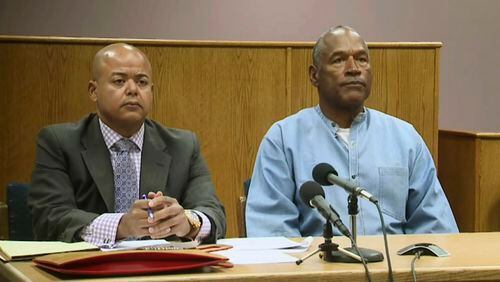 Former NFL football star O.J. Simpson appears with his attorney, Malcolm LaVergne, left, via video for his parole hearing at the Lovelock Correctional Center in Lovelock, Nev., on Thursday, July 20, 2017.  Simpson was convicted in 2008 of enlisting some men he barely knew, including two who had guns, to retrieve from two sports collectibles sellers some items that Simpson said were stolen from him a decade earlier. (Lovelock Correctional Center via AP)