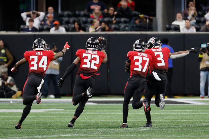Falcons players react after safety Jaylinn Hawkins (32) intercepted a pass by the Bears' Justin Fields in the fourth quarter Sunday at Mercedes-Benz Stadium. The Falcons defeated the Bears 27-24. (Miguel Martinez / miguel.martinezjimenez@ajc.com)
 