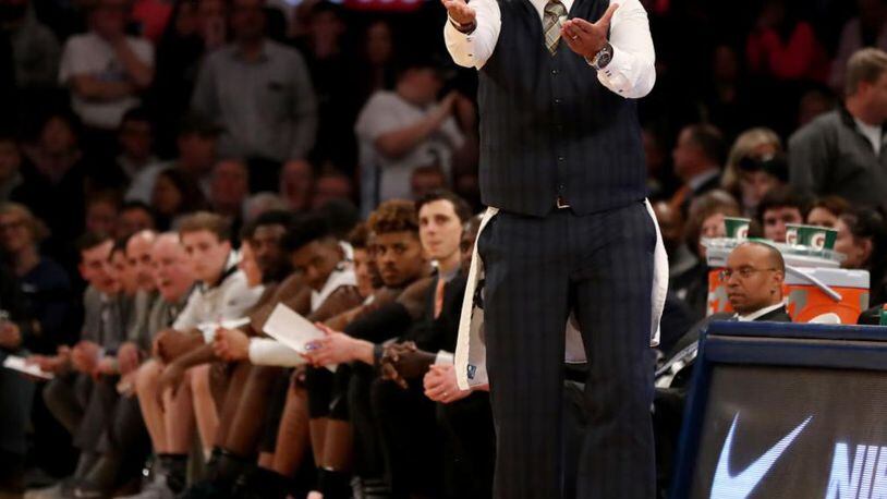 Providence basketball coach Ed Cooley wears a towel as he  shouts instructions to his players during overtime Saturday at the Big East tournament.