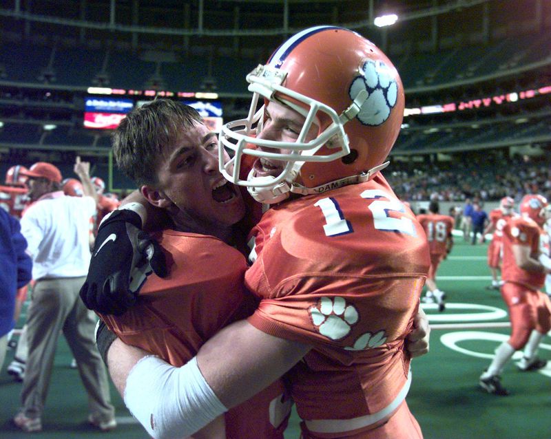Parkview's Jeremy Muyres (No. 12) is hugged by quarterback Buster Faulkner after their overtime defeat of Colquitt County in the semifinals of the Class AAAA playoffs at the Georgia Dome. Muyres hauled in four interceptions and scored the overtime touchdown Dec. 12, 1997. (Jonathan Newton/AJC file)