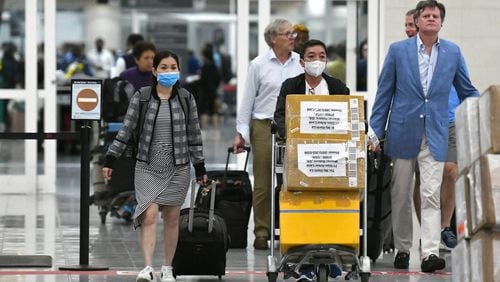 International travelers wearing masks arrive at Hartsfield-Jackson International Airport Tuesday, March 3, 2020. (Hyosub Shin / Hyosub.Shin@ajc.com)