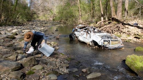 Volunteer Rhett Rutherford bags trash along Proctor Creek during Sweep The Hooch day in Atlanta on Saturday, March 26, 2021. Proctor Creek runs through Atlanta and ultimately empties into the Chattahoochee River. STEVE SCHAEFER FOR THE ATLANTA JOURNAL-CONSTITUTION