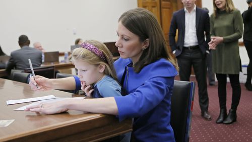 Stacey Evans, with her 6-year-old daughter Ashley on her lap, fills out the paperwork to qualify for the governor's race in 2018. BOB ANDRES  /  BANDRES@AJC.COM
