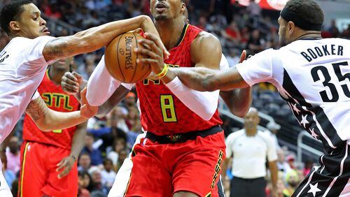 Hawks center Dwight Howard draws a foul on a rebound during a double team by Brooklyn Nets K.J. McDaniels (left) and Trevor Booker in a NBA basketball game on Sunday, March 26, 2017, in Atlanta.   Curtis Compton/ccompton@ajc.com