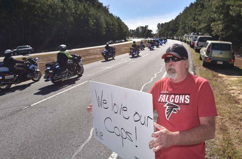 October 24, 2018 Lawrenceville - Stan Rainey holds a sign to show his respect during the procession of slain Gwinnett County police officer Antwan Toney outside 12Stone Church on Buford Drive on Wednesday, October 24, 2018. Gwinnett County police officer Antwan Toney, 30, was shot and killed Saturday while responding to a call in the Snellville area. The California native worked for nearly three years for the Gwinnett police department. A funeral was hold at 11 a.m. Wednesday at 12Stone Church, 1322 Buford Drive in Lawrenceville. HYOSUB SHIN / HSHIN@AJC.COM