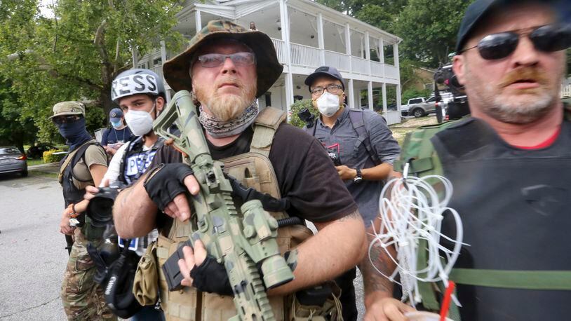 Georgia Security Force III% militia leader Chris Hill (center) stands with allies at a rally Saturday, Aug. 15, 2020, in Stone Mountain, Georgia, while a broad coalition of leftist anti-racist groups organized a counter-demonstration. (Jenni Girtman/Atlanta Journal-Constitution/TNS)