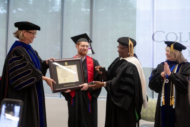 Columbus State University President Stuart Rayfield (left) presents Grant Martin his diploma. Annice Yarber-Allen, dean of the College of Letters and Science, and Margie Yates, dean of the College of Education and Health Professions (right), were also in attendance Saturday.