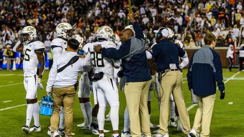 Georgia Tech character-development coach Derrick Moore (holding baton) huddles with a special-teams unit before it goes onto the field in the team's 27-21 win over Miami on Nov. 10, 2018. (Danny Karnik/Georgia Tech Athletics)