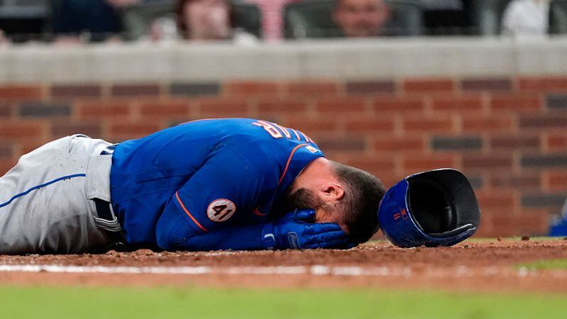 New York Mets outfielder Kevin Pillar lies on the ground after being hit in the face with a pitch from Braves reliever Jacob Webb in the seventh inning Monday, May 17, 2021, in Atlanta. (John Bazemore/AP)