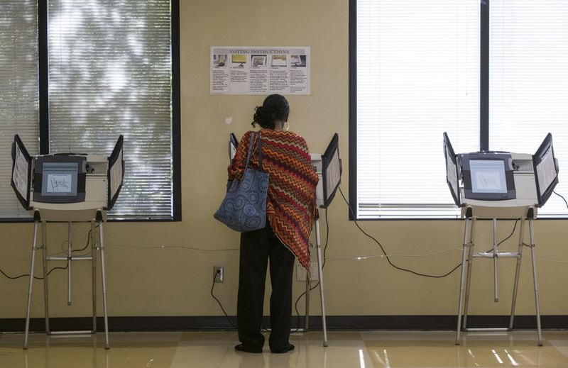 A woman votes at the Fulton County Government Center in Atlanta on Oct. 26, the first day of early voting in Atlanta. (CASEY SYKES / CASEY.SYKES@AJC.COM)