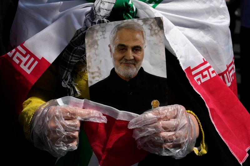 A worshipper holds a portrait of the late Iranian Revolutionary Guard Gen. Qassem Soleimani, who was killed in a U.S. drone attack in 2020 in Iraq, during an anti-Israeli gathering after Friday prayer in Tehran, Iran, Friday, April 19, 2024. An apparent Israeli drone attack on Iran saw troops fire air defenses at a major air base and a nuclear site early Friday morning near the central city of Isfahan, an assault coming in retaliation for Tehran's unprecedented drone-and-missile assault on the country. (AP Photo/Vahid Salemi)