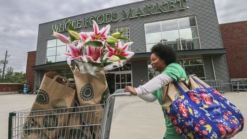 Zyra Money, a personal shopper, leaves the Whole Foods Market at Buckhead Market Place. “We’ll wait and see, hopefully it won’t change,” she said when asked about Amazon’s nearly $14 billion deal to buy Texas-based Whole Foods. JOHN SPINK/JSPINK@AJC.COM.