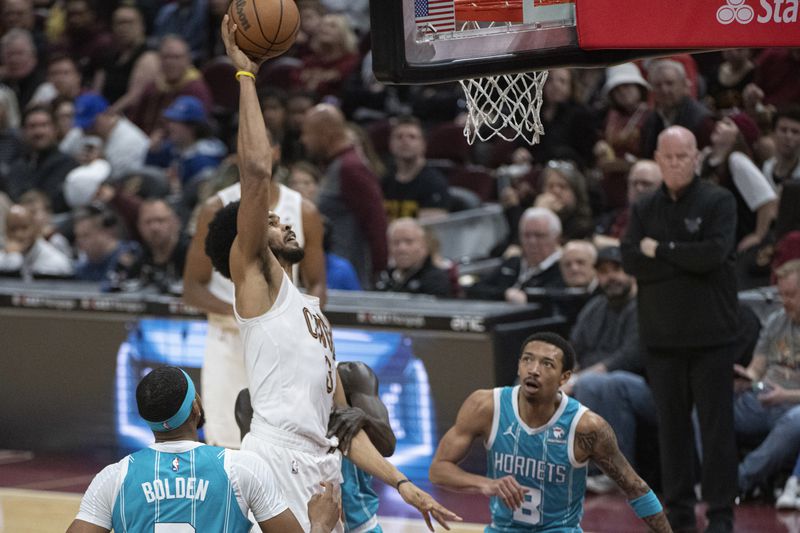 Cleveland Cavaliers' Jarrett Allen (31) dunks as Charlotte Hornets' Marques Bolden (3) and Nick Smith Jr. (8) watch during the first half of an NBA basketball game in Cleveland, Sunday, April 14, 2024. (AP Photo/Phil Long)