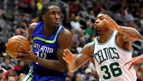 Hawks forward Taurean Prince (12) looks to pass as Celtics guard Marcus Smart (36) defends in the second half of an NBA basketball game on Thursday, April 6, 2017, in Atlanta. (AP Photo/Todd Kirkland)