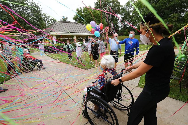 COVID-19 survivor Irma Gooden is showered with confetti by family, friends and staff as director of activities Brock Staples wheels her outside to celebrate her 100th birthday at Westbury Medical Care & Rehab on Tuesday, June 16, 2020, in Jackson. Gooden is one of more than 80 residents at Westbury Medical Care and Rehab who tested positive for COVID-19 and recovered. CURTIS COMPTON / CCOMPTON@AJC.COM