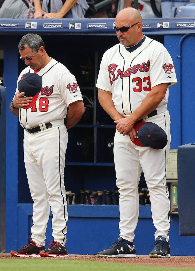 Then-Braves manager Fredi Gonzalez (right) and bench coach Carlos Tosca observe a moment of silence for baseball fan Gregory Murrey, 60, Alpharetta, on Aug. 30, 2015. The previous day, Murrey who fell at least 40 feet to his death from the top deck at Turner Field. (Curtis Compton/ccompton@ajc.com)