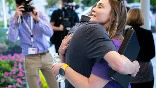 Katie Rinderle (right) embraces Jack Lakis, a recent Harrison High School graduate, after a Cobb County school board meeting in Marietta on Thursday, Aug. 17, 2023. The school board voted to fire Rinderle, who read a book that challenges gender norms to fifth grade students. (Arvin Temkar / arvin.temkar@ajc.com)