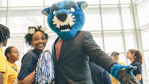 Southwest DeKalb High School senior Kalen Jones poses with Pounce the panther, Georgia State University's mascot, after GSU and State Farm officials announced Wednesday that Kalen was one of 14 students from the school to receive scholarships to the Georgia State University - Perimeter College Decatur campus.