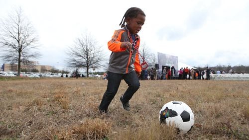 Harley Chapman plays with his newly acquired soccer ball at the end of the unveiling of the Atlanta Sports City sports complex site in Stonecrest on Wednesday. HENRY TAYLOR / HENRY.TAYLOR@AJC.COM