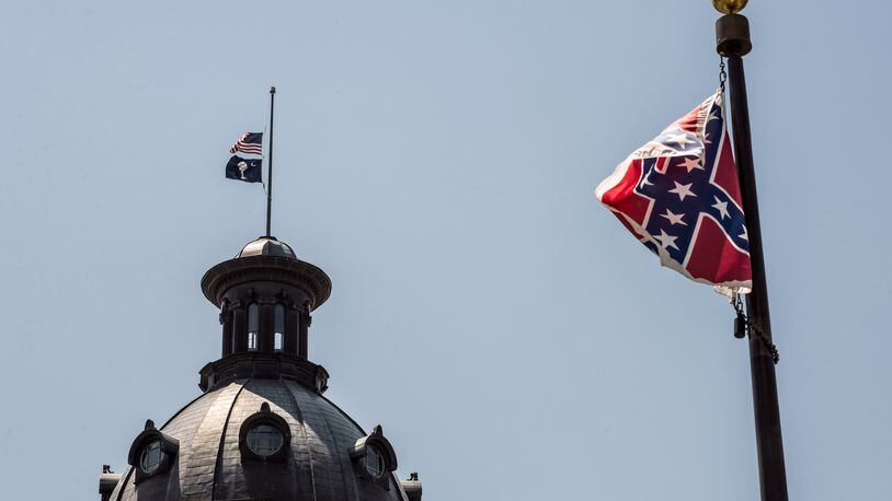 The South Carolina and American flags fly at half-mast as the Confederate flag unfurls below at the Confederate monument June 18, 2015 in Columbia, S.C. Sean Rayford/Getty Images