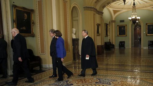 Chief Justice of the United States John Roberts, right, walks to the Senate chamber at the Capitol in Washington, Thursday, Jan. 16, 2020. (AP Photo/Julio Cortez)