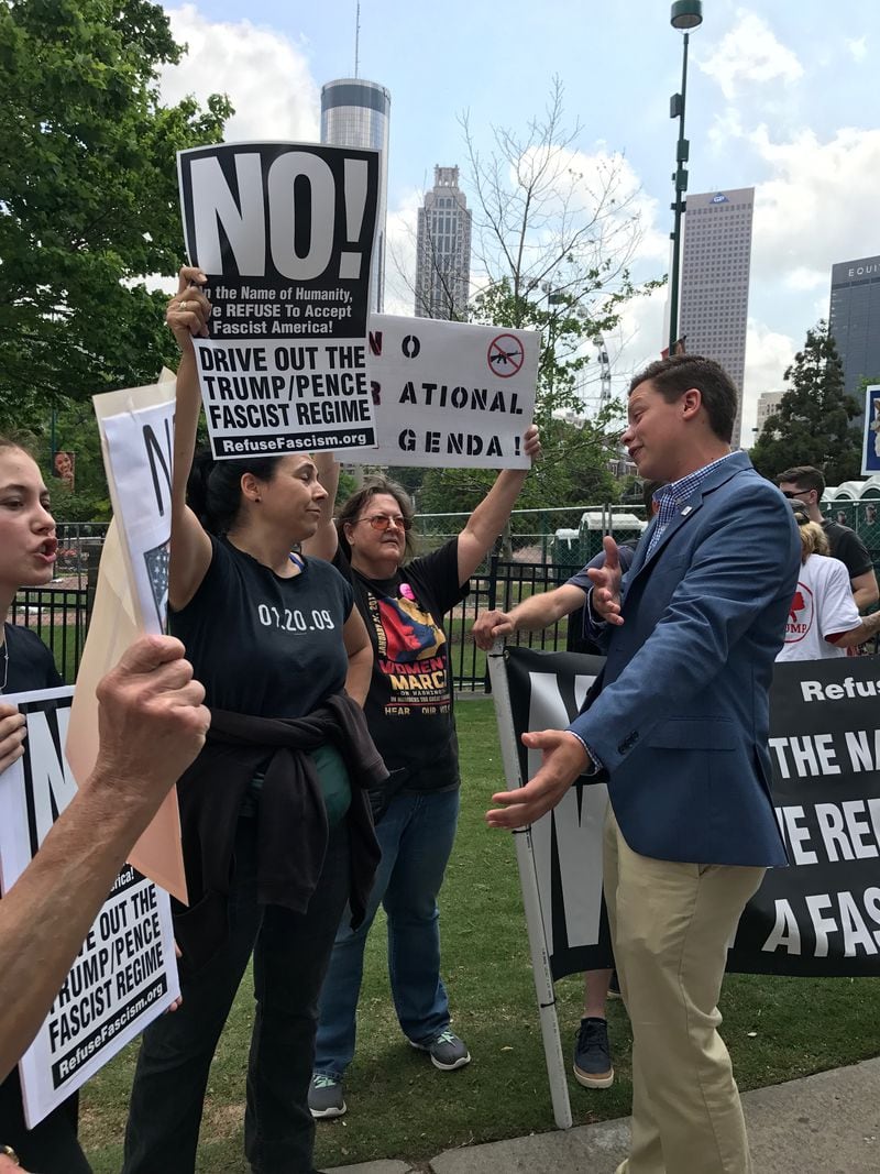 Christian Lemke, right, of Columbia South Carolina, appealed for a dialogue with protesters at Centennial Olympic Park gathering in advance of President Donald Trump's April, 28, 2017, speech at the National Rifle Association’s convention in Atlanta.