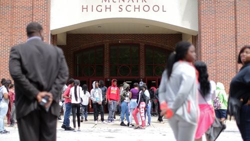 Students wait on buses at dismissal time at Ronald E. McNair High School in DeKalb County in 2016. (AJC FILE PHOTO)