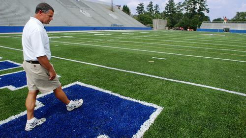 McEachern High School head football coach Jimmy Dorsey inspects the newly-installed artificial playing surface at the school's Walter Cantrell Stadium in 2003.