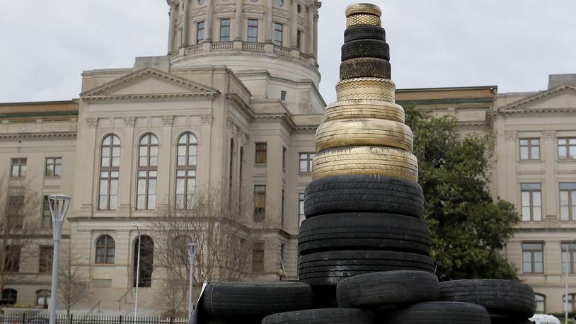 Residents from across the state held a rally across from the Georgia Capitol, using scrap tires to build a replica of the statehouse in Liberty Plaza that they dubbed the “Scrapitol.” They were advocating for legislation forcing the state to stop raiding trust funds for things such as tire dump and hazardous waste cleanups and driver’s education programs. Lawmakers are considering a proposed constitutional amendment that would allow legislators to safeguard such fee-funded programs. BOB ANDRES /BANDRES@AJC.COM