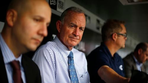 Braves president of baseball operations John Hart, center, and general manager John Coppolella, left, meet with reporters in the dugout before a game against the Pittsburgh Pirates Tuesday night. (AP photo)