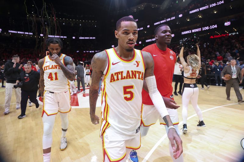 Atlanta Hawks guard Dejounte Murray (5) walks off of the court with Atlanta Hawks forward Saddiq Bey (41) and Atlanta Hawks center Clint Capela (15) after Murray made the game-winning two-point basket as time expires during the fourth quarter against the Orlando Magic at State Farm Arena, Wednesday, January 17, 2024, in Atlanta. The Hawks won 106-104. (Jason Getz / Jason.Getz@ajc.com)