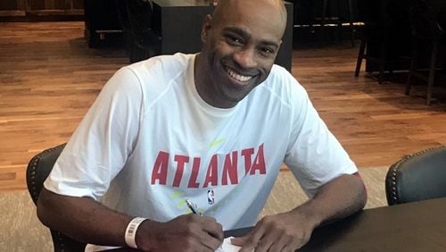 Vince Carter signs his one-year contract with the Hawks Friday.