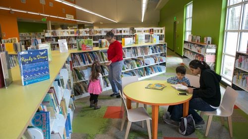 In this file photo, Margarita Sleeper of Roswell and her granddaughter Emma Racine (left), 2, choose a book as Divya Patel (right) of Milton reads a book to her son Nikhil, 4, in the Children’s Book section at the Milton Library. This location will remain open as other Fulton County libraries close for renovations.