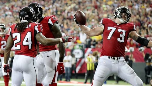 Falcons running back Devonta Freeman hands off the ball to offensive lineman Ryan Schraeder to spike after he scores a touchdown against the Packers on Sunday, Oct. 30, 2016, at the Georgia Dome in Atlanta.