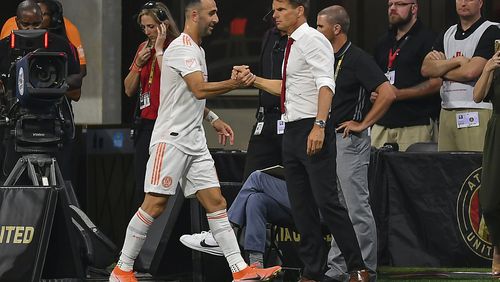 Atlanta United's Justin Meram (14) is congratulated by head coach Frank de Boer (right) after being subbed off against the Montreal Impact June 29, 2019, at Mercedes Benz Stadium in Atlanta. (Rich von Biberstein/Icon Sportswire)